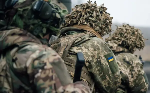 Żołnierze w kamuflażu, z ukraińską flagą na ramieniu, gotowi do akcji. Myślą o domu, ale nie o dezercji.