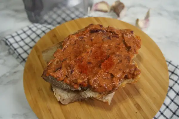 Pyszna pasta z czerwonej fasoli na kromce chleba, posypana papryką. Idealna na szybką przekąskę.