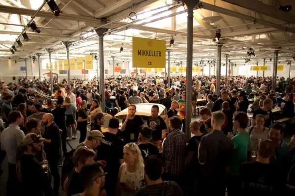 Folla entusiasta a un evento di degustazione di birra Mikkeller.