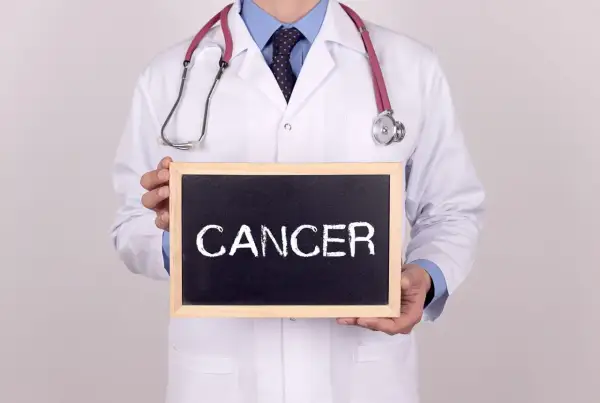 Lekarz w białym kitlu trzyma tabliczkę z napisem "CANCER". Co to znaczy nowotwór low grade?