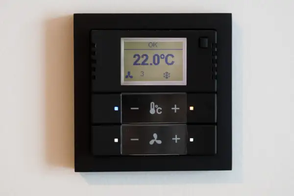 Panel klimatyzacji hotelowej z wyświetlaczem temperatury 22°C i przyciskami sterowania.
