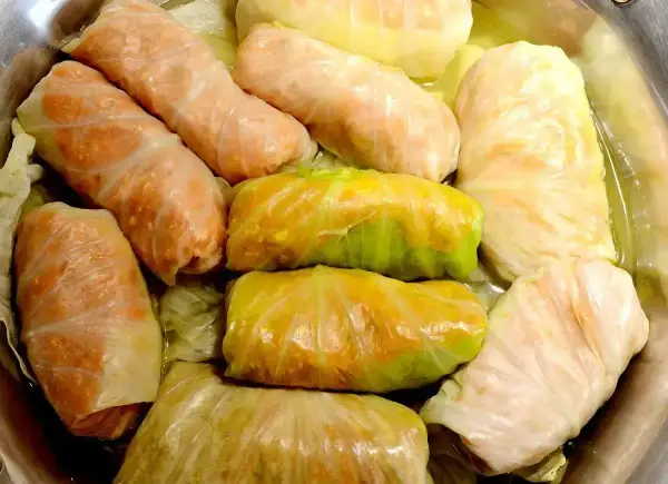 Gołąbki gotowe do pieczenia, idealne na przepis na gołąbki na 1kg mięsa. Widać różnorodność farszu i liści kapusty.
