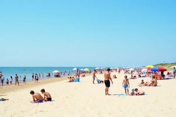 Tłum ludzi na plaży, idealne miejsce na wakacje. Gdzie najbliżej nad morze z Warszawy? Tutaj!