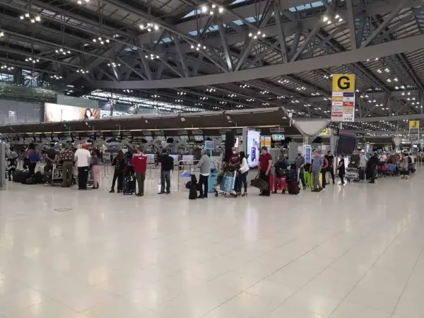 Menschen stehen in einer Schlange am Flughafen-Check-in. Gute **Kiwi com Erfahrungen** sind wichtig für entspanntes Reisen.