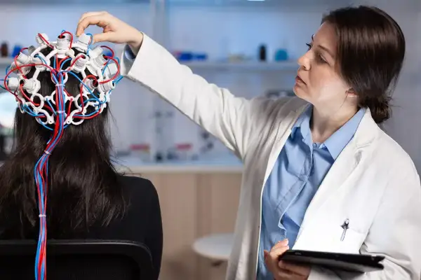 Lekarka zakłada pacjentce czepiec EEG, badając mózg. To przykład badań w neurologii, co to jest i jak działa.