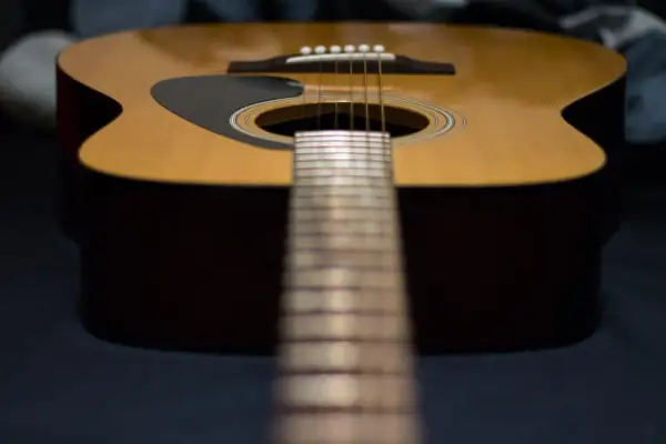 Nahaufnahme einer Akustikgitarre mit Fokus auf die Saitenlage.