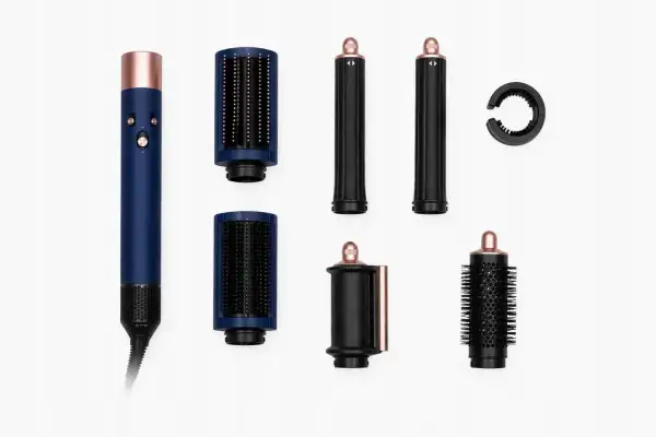 Niebieski styler do włosów Dyson z akcesoriami: szczotki, lokówki i okrągła końcówka.