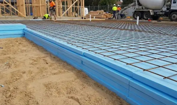 Budowa fundamentów z użyciem styroduru zamiast wylewki. Na niebieskich płytach izolacyjnych ułożono zbrojenie.