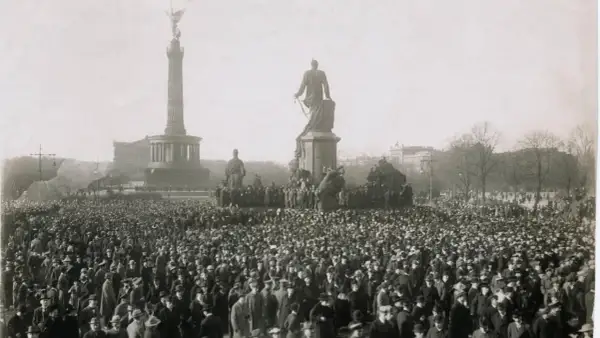 Menschenmenge vor dem Siegessäule-Denkmal in Berlin, ein Symbol der revolutionären Stimmung der Revolution 1918.