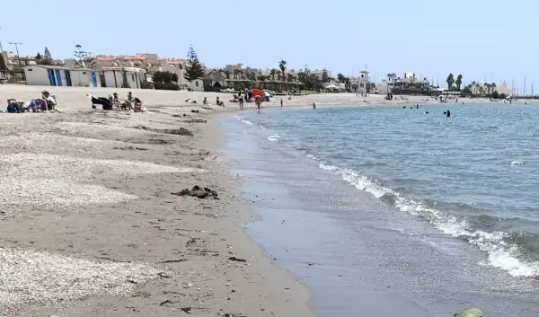 Gente disfrutando de un día soleado en la playa de Almerimar. Las opiniones sobre este lugar son muy positivas, ideal para relajarse.