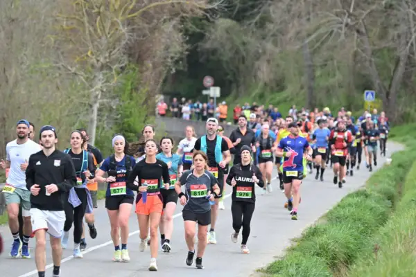 Course à pied dans le Gers, des coureurs concentrés sur la route, le souffle de la compétition dans l'air.