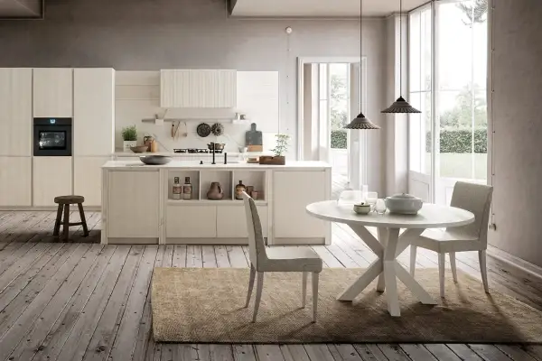 Cucina chiara con isola centrale e tavolo rotondo. Ecco come abbinare il tavolo alla cucina per un look armonioso.