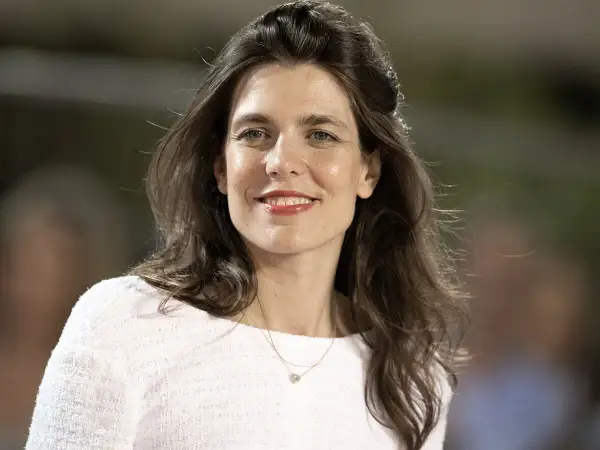 Charlotte Casiraghi sonríe con un collar delicado y un suéter blanco.