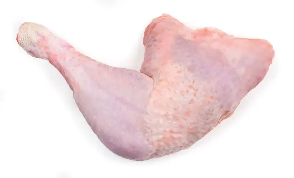 Una zampa di tacchino cruda, con la pelle rosata e squamosa alla fine, pronta per essere cucinata.