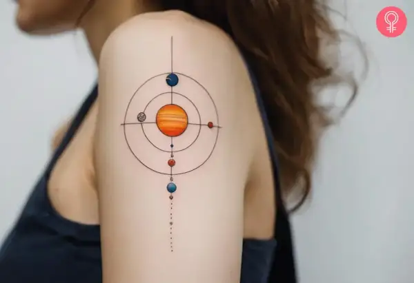 Tatuajes del sistema solar en el hombro, con el sol naranja en el centro y planetas coloridos orbitando.
