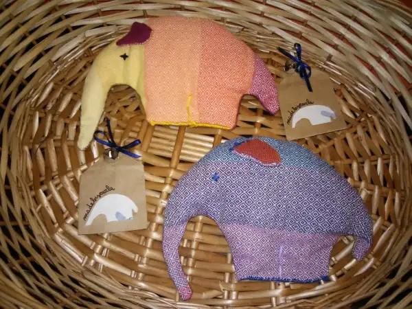 Due elefantini di stoffa colorati, perfetti per lavoretti con la stoffa per bambini. Uno arancione e giallo, l'altro viola e blu, con etichette "made by carla".