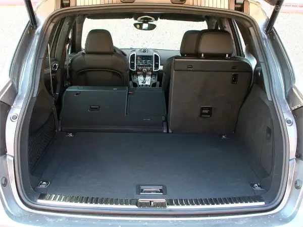 Maletero de un Porsche Cayenne, mostrando su amplitud y los asientos traseros abatibles. Ideal para conocer las porsche cayenne medidas de carga.