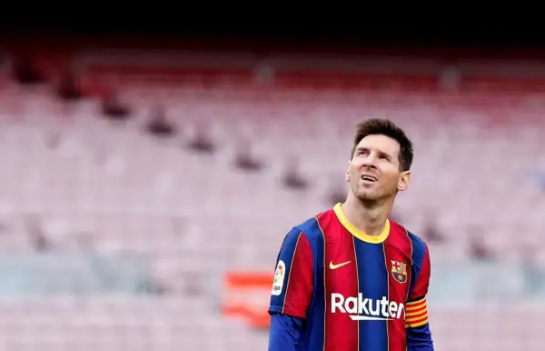 Messi w Barcelonie, w swoim charakterystycznym stroju, spogląda w górę na trybuny stadionu.