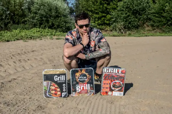 Mężczyzna w hawajskiej koszuli prezentuje trzy grille jednorazowe, gotowe na piknik.