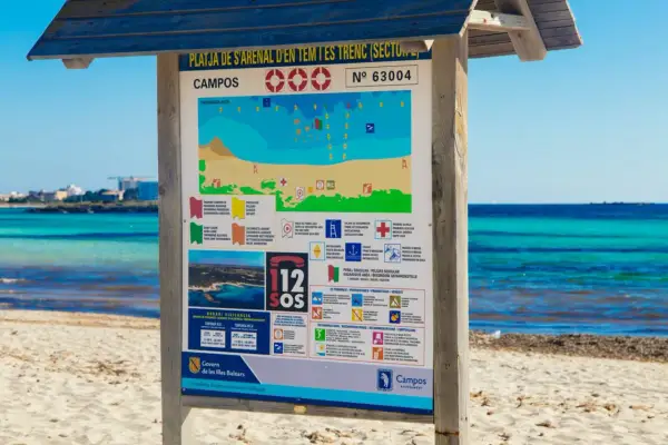 Tablica informacyjna na plaży Campos, Majorka. Znajdziesz tu mapę, zasady bezpieczeństwa i co zabrać na majorkę, by cieszyć się słońcem i morzem.