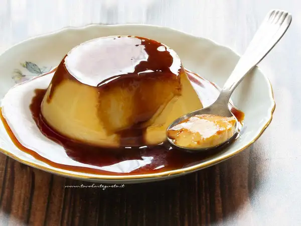Delizioso creme caramel su un piatto bianco, con una cucchiaiata pronta da gustare.