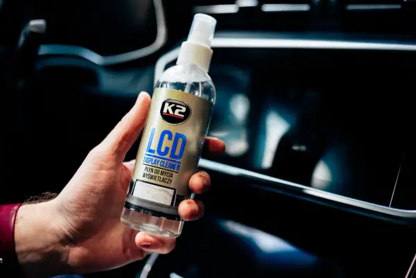 Dłoń trzyma płyn K2 LCD Display Cleaner, idealny do czyszczenia ekranu telefonu.