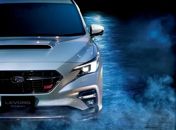 Srebrny Subaru Levorg STI Sport z włączonymi światłami, otoczony niebieską mgłą, gotowy do jazdy.