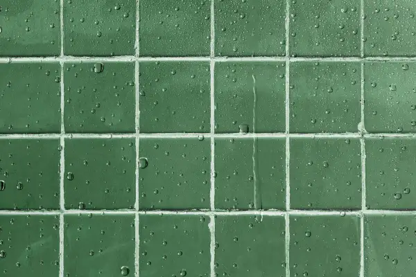 Gouttes d'eau sur un carrelage vert, montrant l'efficacité d'un traitement pour imperméabiliser un carrelage poreux.