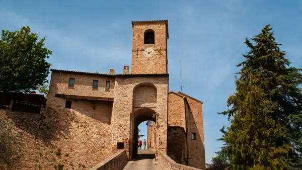 Porta Urbica a Montefeltro: un arco in mattoni con torre dell'orologio, ideale per scoprire cosa vedere in questo borgo storico.