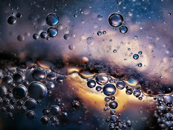 Close-up of oil and water bubbles with iridescent colors and reflections.