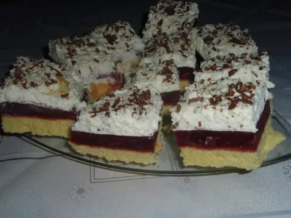 Pyszne ciasto wiśniowa fantazja z puszystą bitą śmietaną i czekoladowymi wiórkami, gotowe do podania.