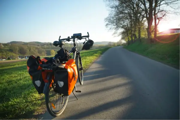 Rower z sakwami na drodze, idealny na długą podróż. Jak nie zasnąć w trasie? Wystarczy piękny widok i cel!