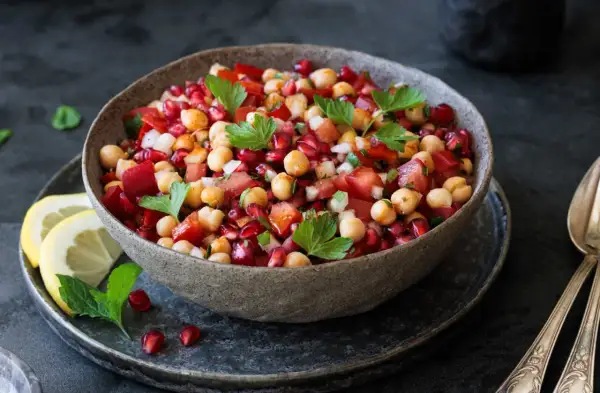 Bunter Kichererbsensalat mit Granatapfelkernen, Tomaten und Petersilie. Perfekt als Beilage oder leichtes Hauptgericht. Was passt zu Kichererbsensalat? Frisches Brot!
