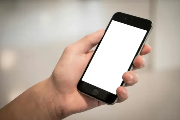 Dłoń trzyma smartfon z pustym ekranem. Cisza, brak id dzwoniącego.