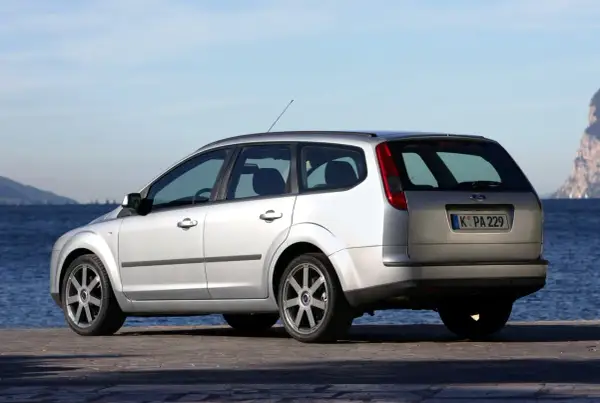 Srebrny Ford Focus MK2 1.6 benzyna na tle błękitnego nieba i morza.