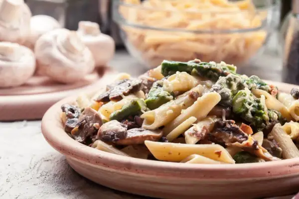 Makaron penne z kurczakiem, szparagami i pieczarkami w kremowym sosie.