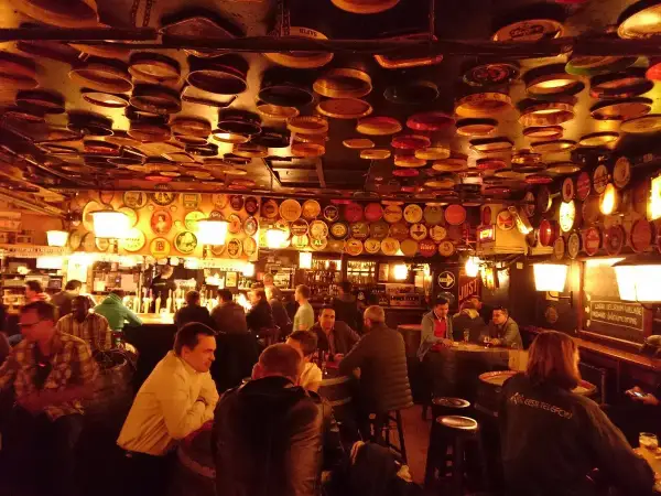 Interno di un locale a Bruxelles, con il soffitto e le pareti ricoperti di tappi e dischi di latta. Un'atmosfera da vero delirium.