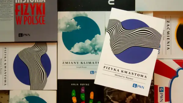 Książki o fizyce kwantowej i historii fizyki w Polsce. Jedna z nich, "Fizyka kwantowa" Michaela G. Raymera, leży na wierzchu.