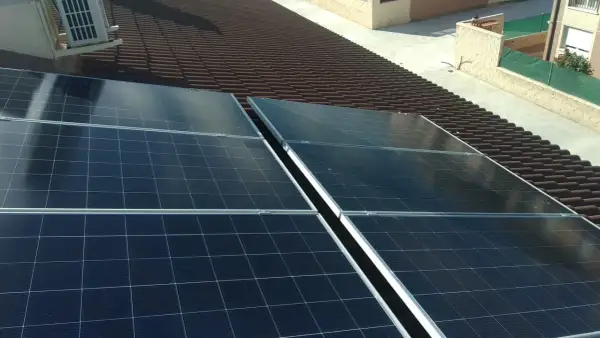Paneles solares en tejado de tejas marrones. La instalación busca la mejor solución para evitar sombras y maximizar la captación solar.