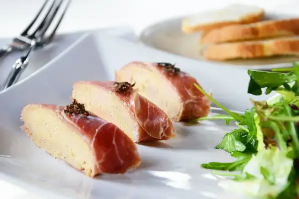 Kawałki pasztetu z wątróbki zawinięte w szynkę parmeńską, posypane ziołami. Idealne na przystawkę, zastanawiasz się, jaka wątróbka najlepsza?