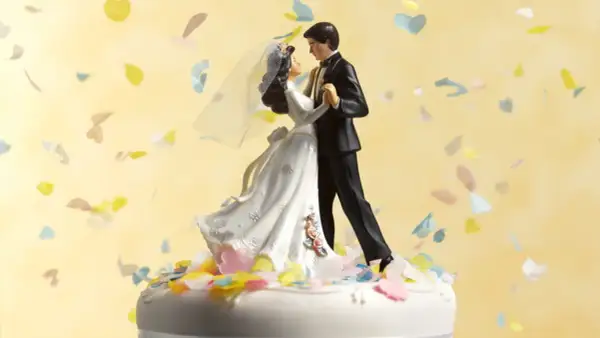 Statua di sposi su torta nuziale, con coriandoli colorati che volano. 75 anni di matrimonio, che nozze sono!