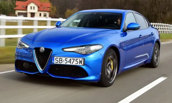 Niebieskie Alfa Romeo Giulia w ruchu, z widocznymi detalami, które mogą być interesujące dla osób szukających informacji o alfa romeo giulia dane techniczne.