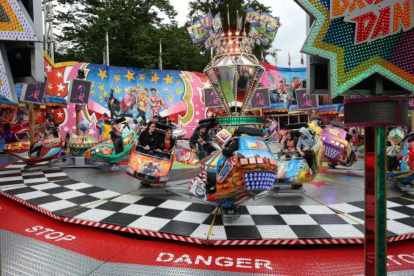 Bunte Fahrgeschäfte drehen sich auf der Kirmes Bergneustadt. Menschen lachen und genießen die Fahrt.