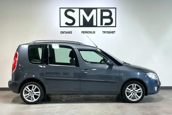 Grå Skoda Roomster, en praktisk familjebil, står redo för nya äventyr. Inga synliga problem med denna bil.