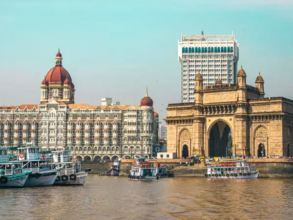 Brama Indii i hotel Taj Mahal Palace w Mumbaju, Indie. Wokół pływają łodzie.