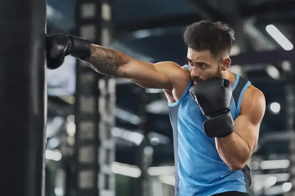 A boxer trains intensely, punching a heavy bag. This workout is a great way to see how many calories does boxing burn, boosting fitness and strength.