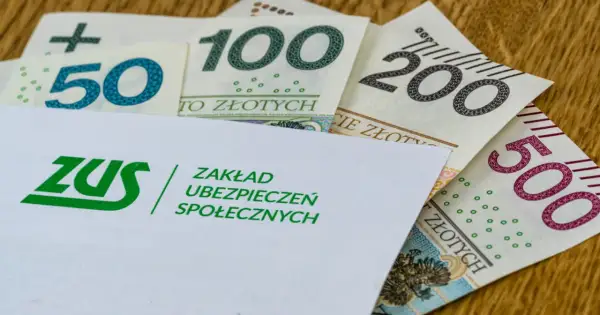 Koperta ZUS z logo i napisem "Zakład Ubezpieczeń Społecznych" na tle polskich banknotów 50, 100, 200 i 500 zł. Symbolizuje świadczenie kompensacyjne.