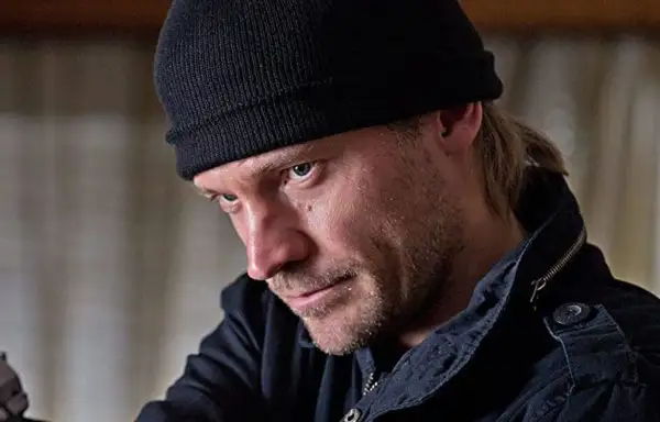 En man med svart mössa och skäggstubb, kanske en karaktär från filmer och tv-program med Jo Nesbø.