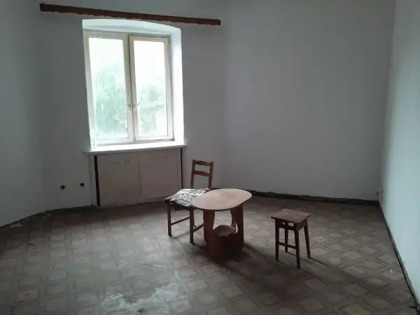 Puste mieszkania za odstępne w Łodzi. Stół, krzesło i stołek czekają na lokatorów.