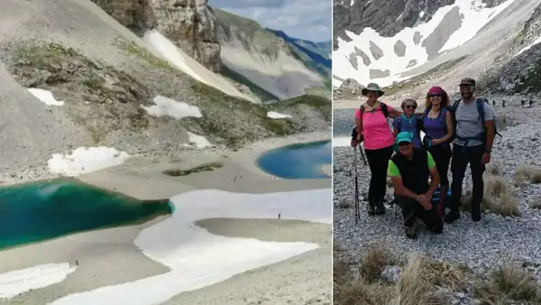 Gruppo di escursionisti al lago di Pilato, con le sue acque turchesi e i nevai circostanti.